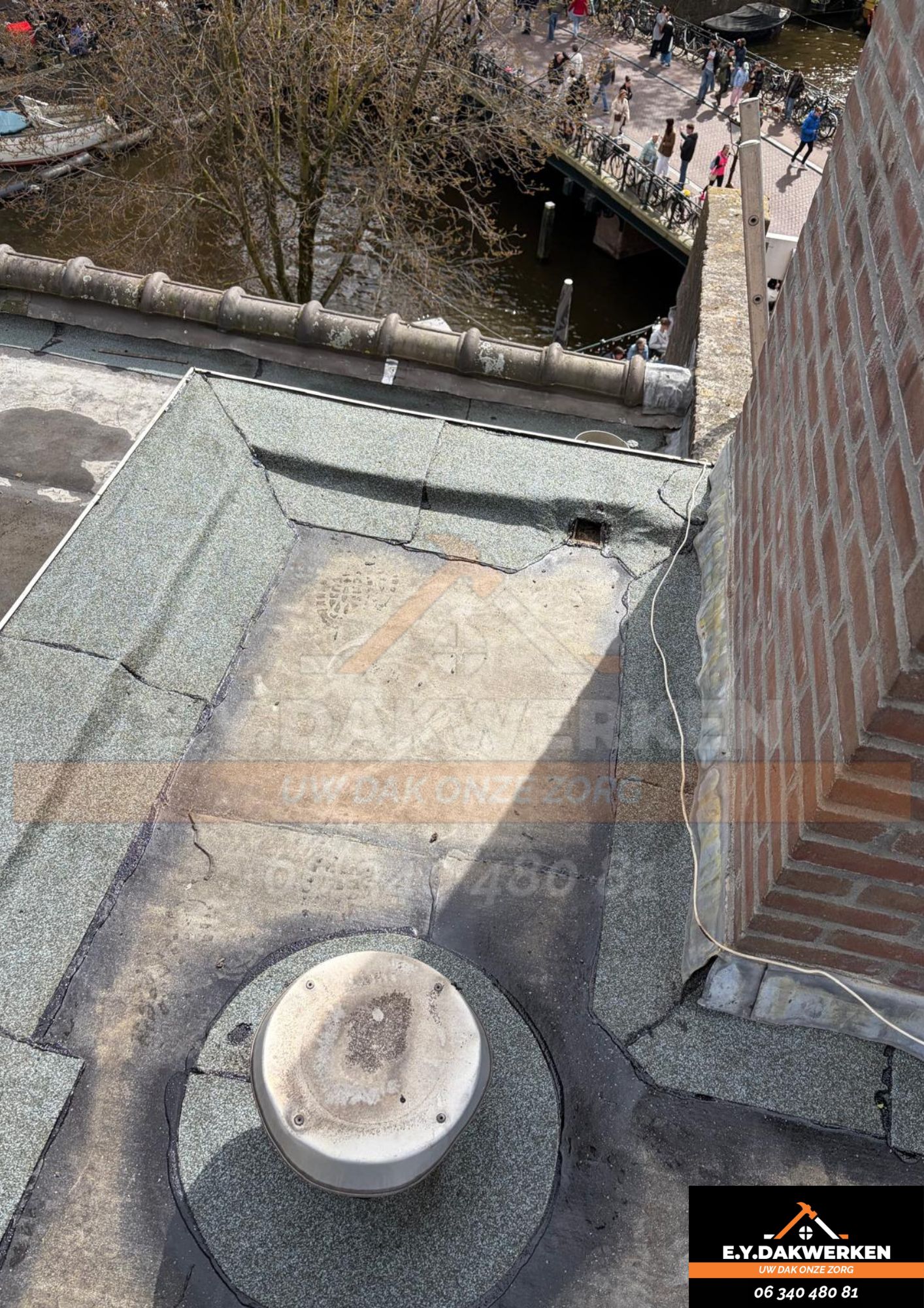 Plat dak met groene leislag en een dakafvoer, hoog boven een gracht